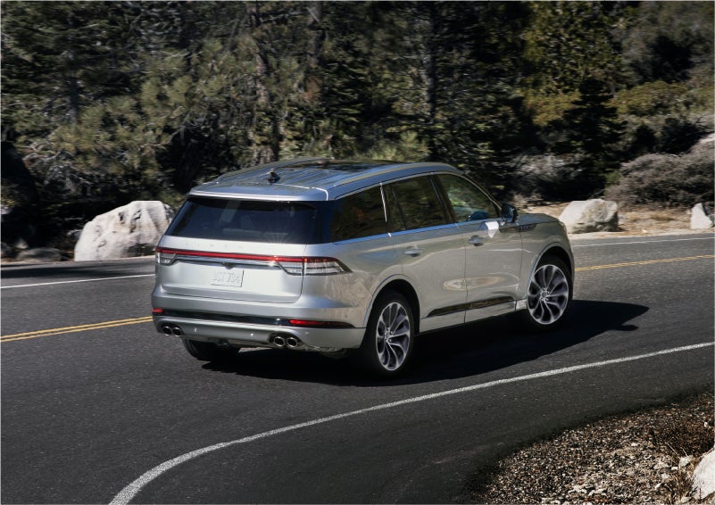 A 2023 Lincoln Aviator® Grand Touring model is shown being driven on a tight turn of a mountain road | Cummins Lincoln in Weatherford OK