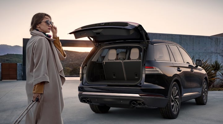 A woman approaches a 2026 Lincoln Aviator® SUV with its rear liftgate open. | Cummins Lincoln in Weatherford OK