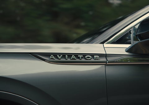The driver’s side door and fender badging of a gray 2027 Lincoln Aviator® SUV are showcased. | Cummins Lincoln in Weatherford OK